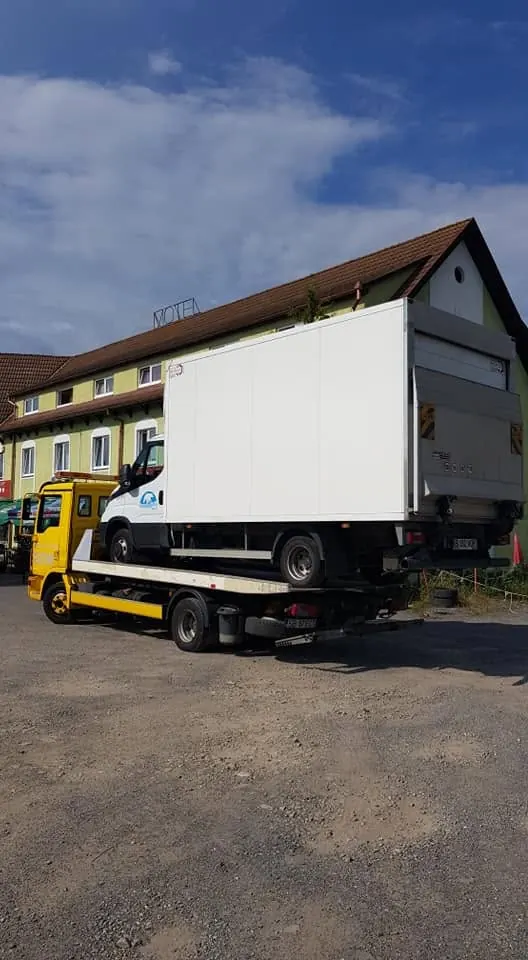 Camion cu box frigorific urcat pe platforma MAN