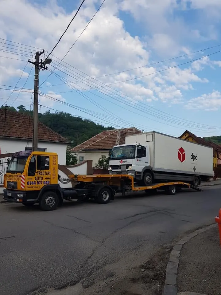 Camion de curierat transportat pe trailerul platformei MAN