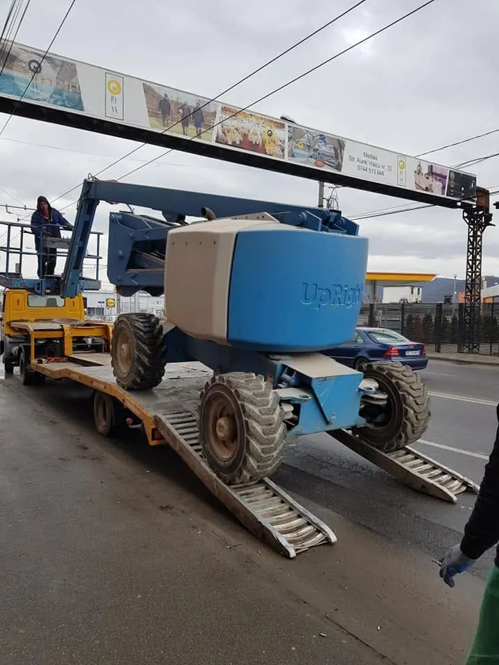 Nacelă articulată urcată pe rampe, pe trailer