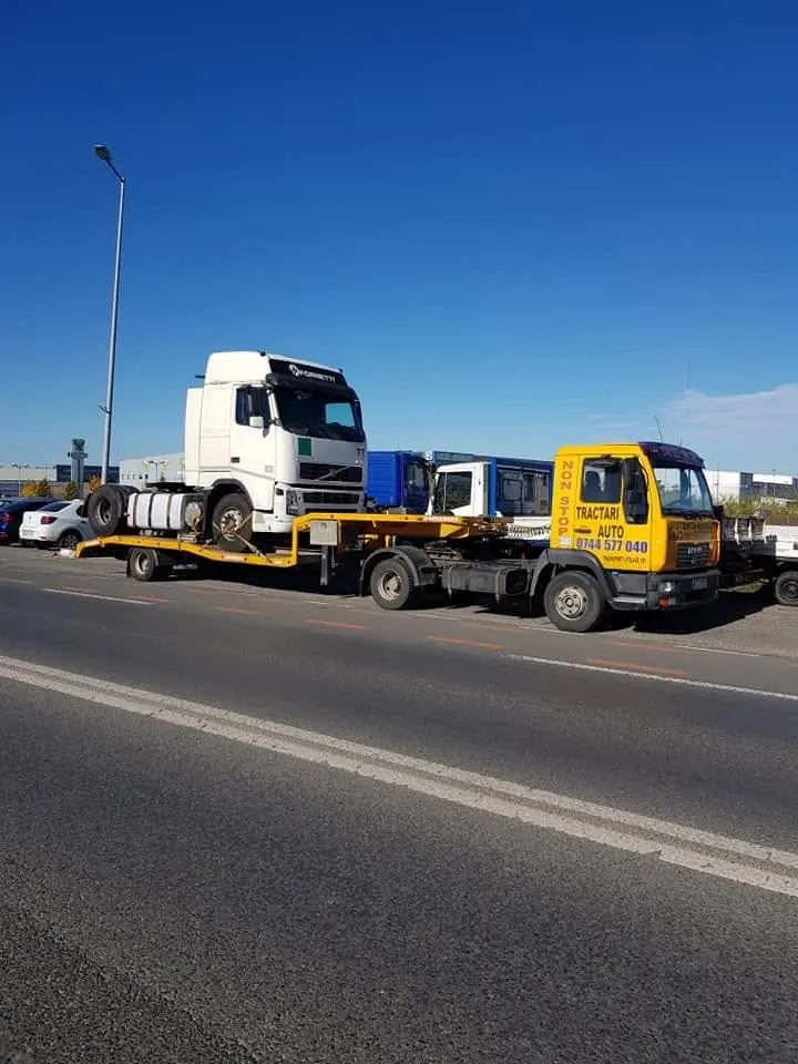 Cap tractor Volvo transportat pe trailer, pe drumul național